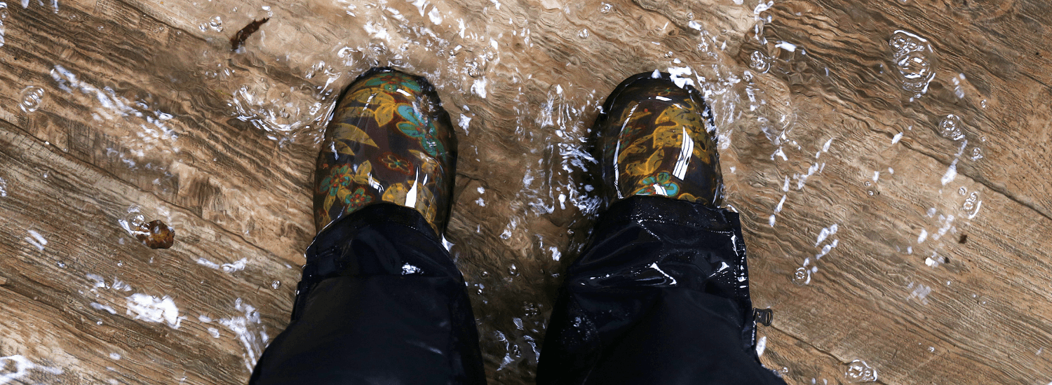 Ariel view of flowery wellington boots standing on flooded wooden floor